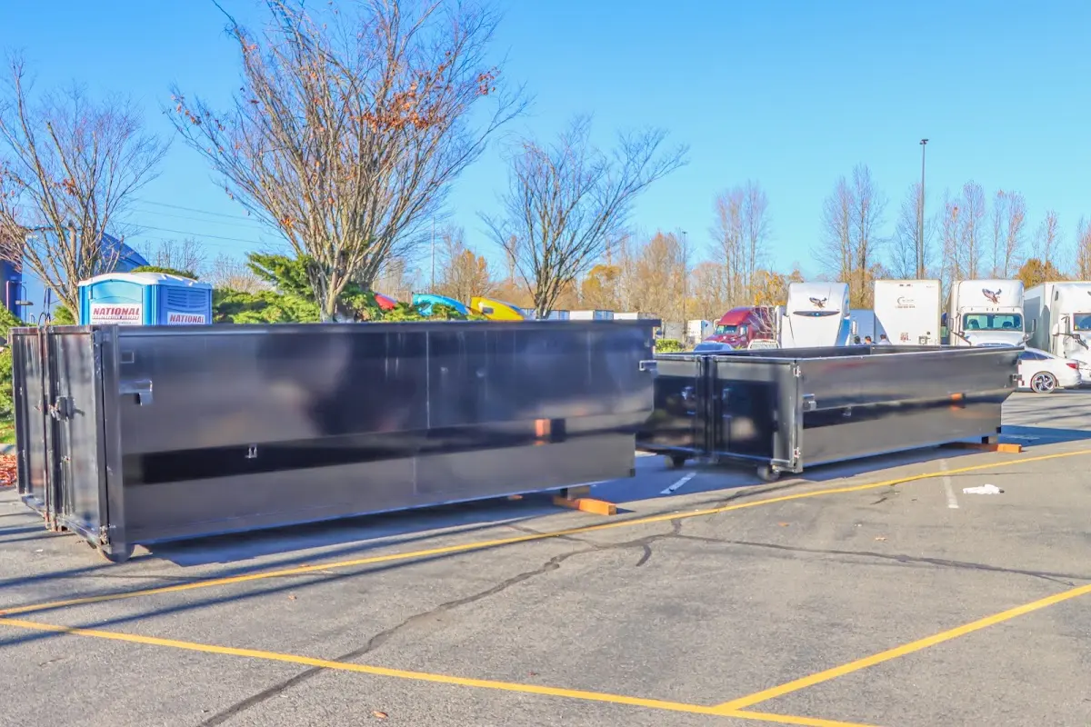 Professional dumpster rental service with roll-off container on residential driveway in Farmersville